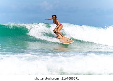 Asian woman surfer surfing and riding surfboard  the wave in the sea at tropical beach in sunny day. Healthy female enjoy outdoor activity lifestyle and water sport exercise surfing on summer vacation - Powered by Shutterstock