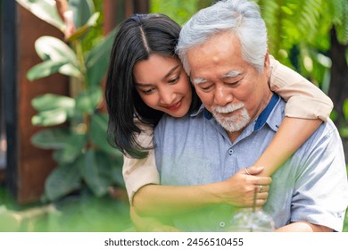 Asian woman surprised elderly father with Birthday gift at outdoor cafe restaurant on summer holiday vacation. Family relationship, celebrating father's day and senior people health care concept. - Powered by Shutterstock