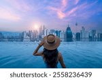 Asian woman in swimsuit by the pool and morning view and sunrise at Kuala Lumpur Malaysia