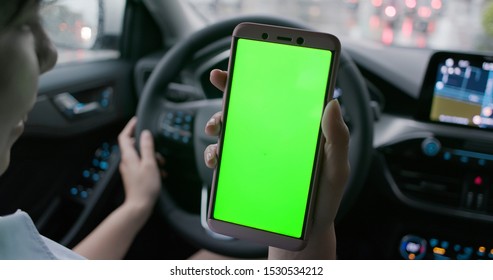 Asian Woman Take Phone With Green Screen In The Car