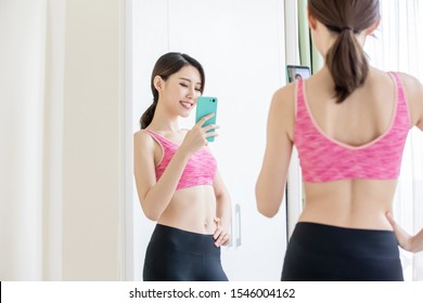 Asian Woman Take Selfie In Front Of Mirror With Sport Wear Happily