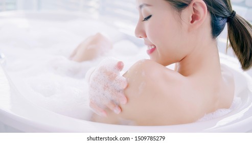asian woman taking a bubble bath in the bathroom
