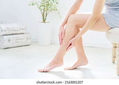 Asian woman taking car of her leg at home, no face - Shutterstock ID 2163001207