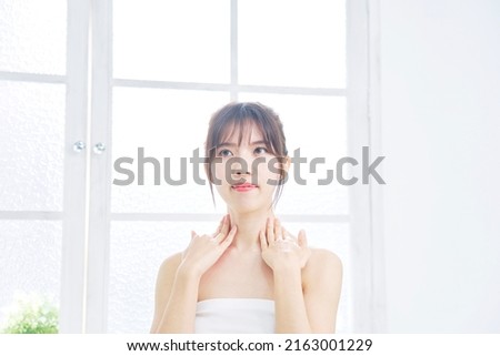 Asian woman taking care of her neck at home