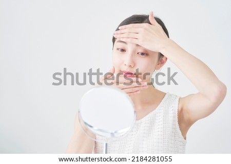 Asian woman taking care of her face at the living room