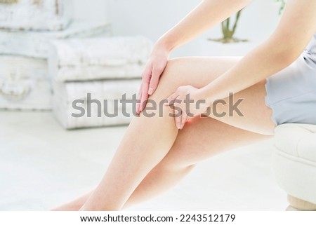 Asian woman taking care of her legs at home, no face