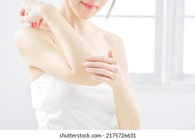 Asian woman taking her elbow care at home, no face