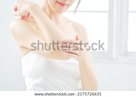 Asian woman taking her elbow care at home, no face
