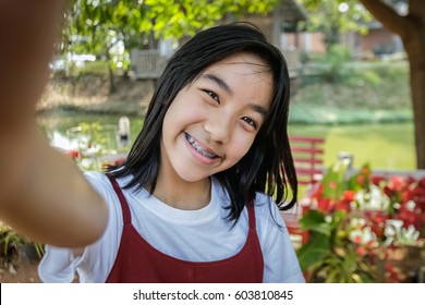 Asian Woman Taking A Selfie In Public Park