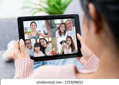 Asian woman talking with family on video call webcam in living room at home while working from home. Self-isolation, social distancing, quarantine for protection coronavirus in next or new normal. - Powered by Shutterstock