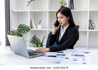 Asian Woman Talking On The Phone, She Is A Salesperson In A Startup Company, She Is Calling Customers To Sell Products And Promotions. Concept Of Selling Products Through Telephone Channels.