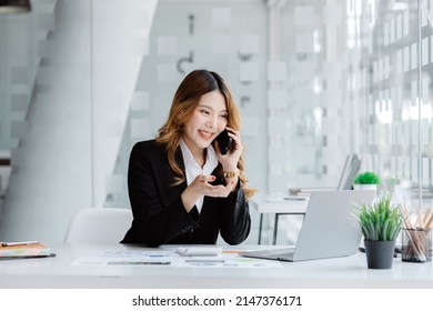 Asian Woman Talking On The Phone, She Is A Salesperson In A Startup Company, She Is Calling Customers To Sell Products And Promotions. Concept Of Selling Products Through Telephone Channels.