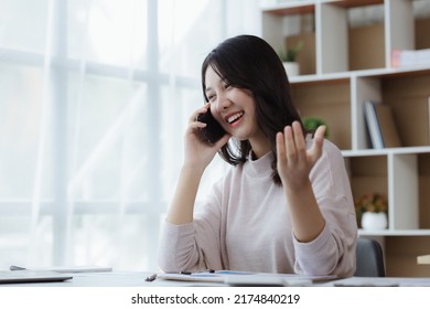 Asian Woman Talking On The Phone, She Is A Salesperson In A Startup Company, She Is Calling Customers To Sell Products And Promotions. Concept Of Selling Products Through Telephone Channels.