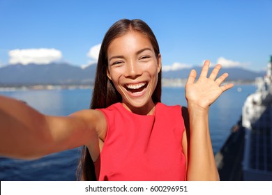 Asian Woman Talking On Video Chat Mobile Phone App Or Taking Selfie Photo For Social Media. Young Businesswoman Using Smartphone Smiling Happy In Sunny Outdoors. Urban Female Professional.