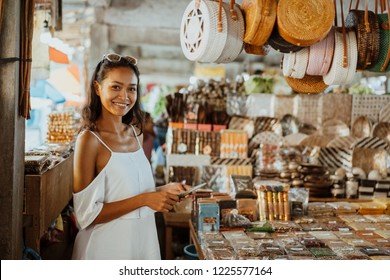 Asian Woman With Tanned Skin In The Souvenir Shop Buying Some Gift