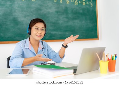 Asian woman teacher teaching and explain with student via video conference e-learning in laptop at classroom. Homeschooling and distance learning ,online ,education and internet.