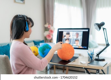 Asian woman teacher teaching solar system via video conference e-learning and cheerful elementary school student looking at globe, Homeschooling and distance learning ,online ,education and internet.