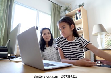 The Asian Woman Teaching Her Child To Use Computer.