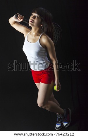 Asian woman with tennis racket isolated on black. Low key shot
