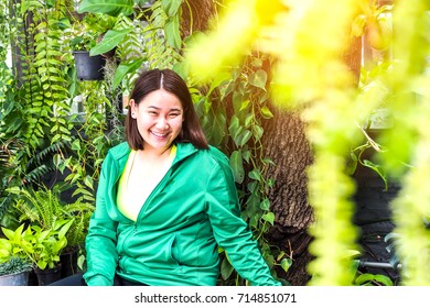 Asian Woman , Thai Girl Wear Green Sport Coat Sitting In The Garden , For Motivate Workout And Green Concept