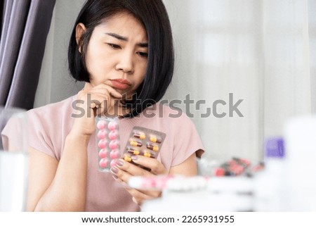 Asian woman thinking and doubt of taking antibiotics and anti-inflammatory drugs together 