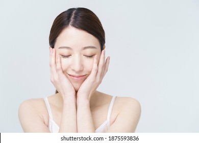 Asian woman touching her face