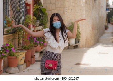 Asian woman touring in Andalusia Spain during covid19 - young happy and beautiful Japanese girl in face mask enjoying holidays travel walking traditional street in Seville town - Shutterstock ID 1934601887
