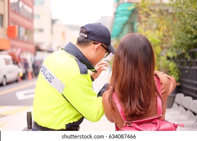 Asian Woman Tourist Asking Policeman For Direction And Information