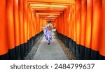 Asian woman in a traditional Japanese kimono walks at Fushimi Inari Shrine in Kyoto. landmarks of  Japan	
