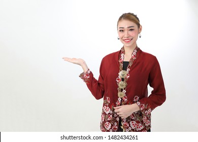 Asian woman traditional red maroon kebaya sharong on white background showing display look palm of hand 