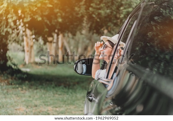 Asian woman travel by car on summer\
holiday. Relax and recreation at natural\
park.