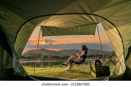 Asian woman travel and camping alone at natural park in Thailand. Recreation and journey outdoor activity lifestyle. Good morning and fresh start of the day. - Shutterstock ID 2122867583