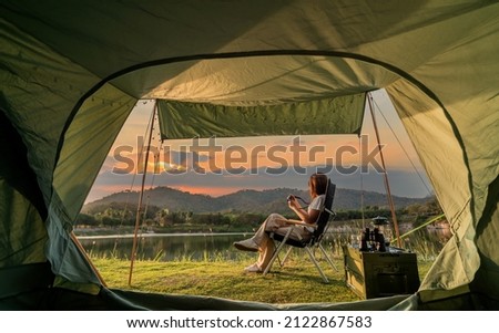 Asian woman travel and camping alone at natural park in Thailand. Recreation and journey outdoor activity lifestyle. Good morning and fresh start of the day.