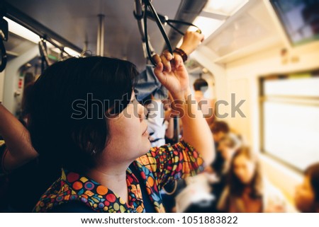 Asian woman travel on skytrain train in city. Many people in city used skytrain to save time.