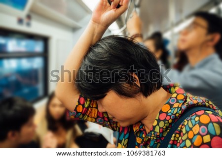 Asian woman travel on skytrain train in city. Many people in city used skytrain to save time.