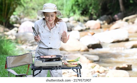 Asian Woman Traveler Grilled Meat For Dinner During Camping Alone Near Creek On Summer Holiday