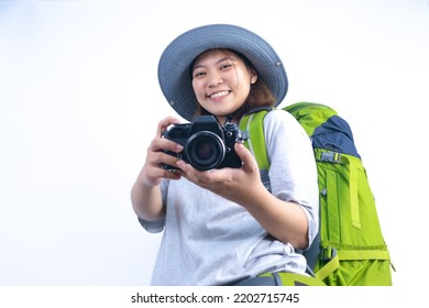 Asian Woman Traveling With Backpack And Bucket Hat Ready To Travel With Camera In White Studio