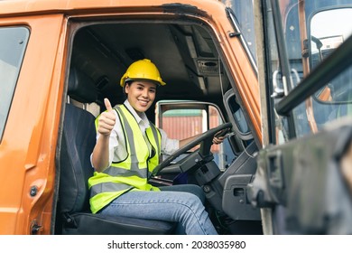 Asian Woman Truck Driver Sitting In Truck Cabin Looking At Camera.