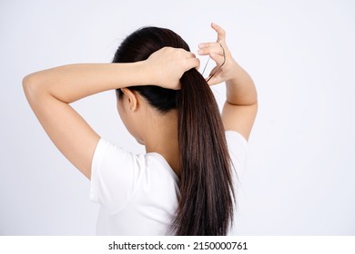 Asian woman tying her hair up isolated on a white background.