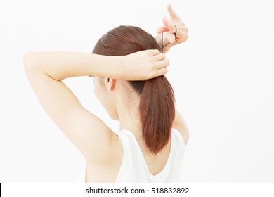 Asian woman tying her hair