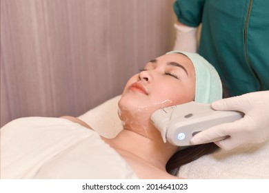 An Asian Woman Undergoes A HIFU Procedure On Her Jawline. A Cosmetic Treatment For Skin Tightening.