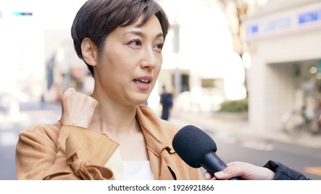 Asian woman undergoing a street interview.