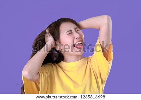 Asian woman unhandled with spicy food, yellow t-shirt clothing, purple background