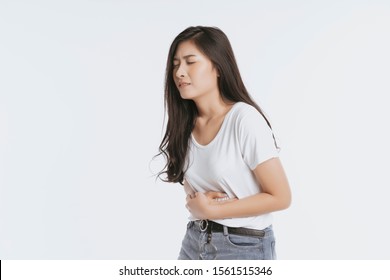 Asian Woman Unhappy Looking Sick, Suffers From Stomach Ache Stomachache Isolated White Background Because Of Menstruation And Eating Spoiled Food, Chronic Gastritis. Abdomen Bloating Concept