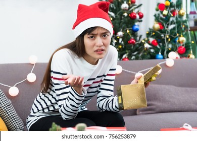 Asian Woman Upset When Open Gold Xmas Gift Box At Holiday Party On Sofa,boredom Christmas Party Present ,bad Emotion