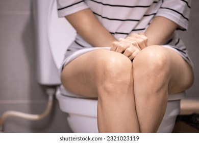 Asian woman urinating in toilet,problem of Polyuria,urination disorders,frequent micturition,urinary incontinence,urinary urgency,overactive bladder,urine frequency,kidney and urinary bladder system