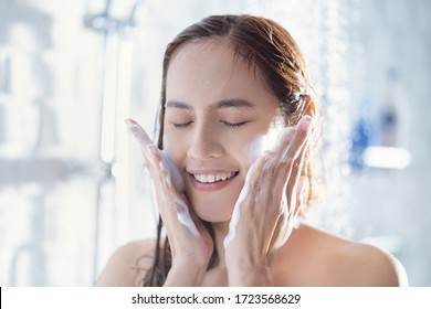 Asian woman use foam to wash your face after showering.