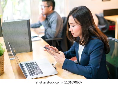 Asian woman use mobile phone email to her customer in modern office 