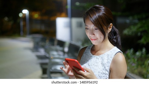 Asian Woman Use Of Mobile Phone In The Park At Night