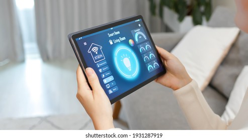 Asian Woman Use Smart Home App To Control Light Turning On With Tablet Pc
